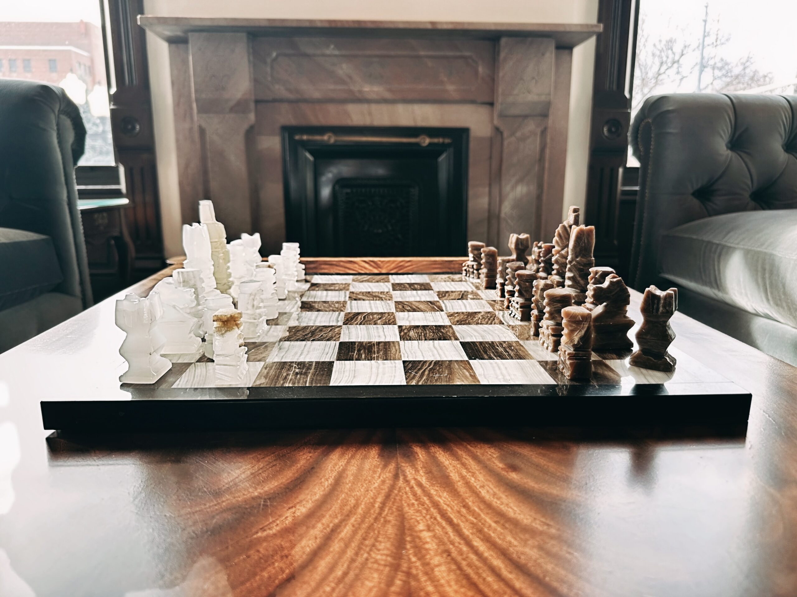 Marble chess set on mahogany table in Parker and Parker law office lobby with leather chairs and carved marble fireplace